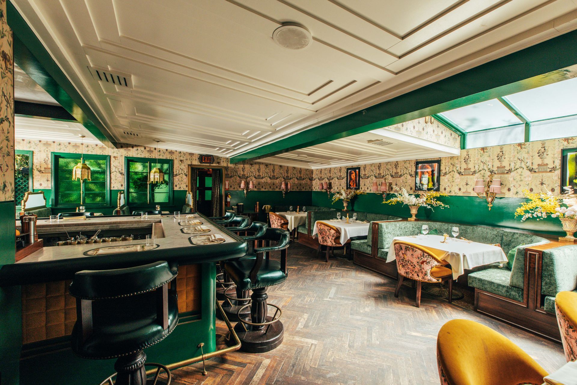 A large room with tables and chairs and a bar.