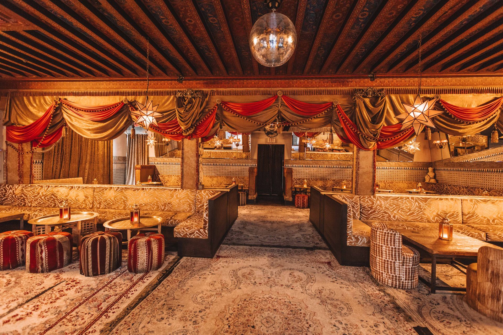 A large room with tables and chairs and a disco ball hanging from the ceiling.