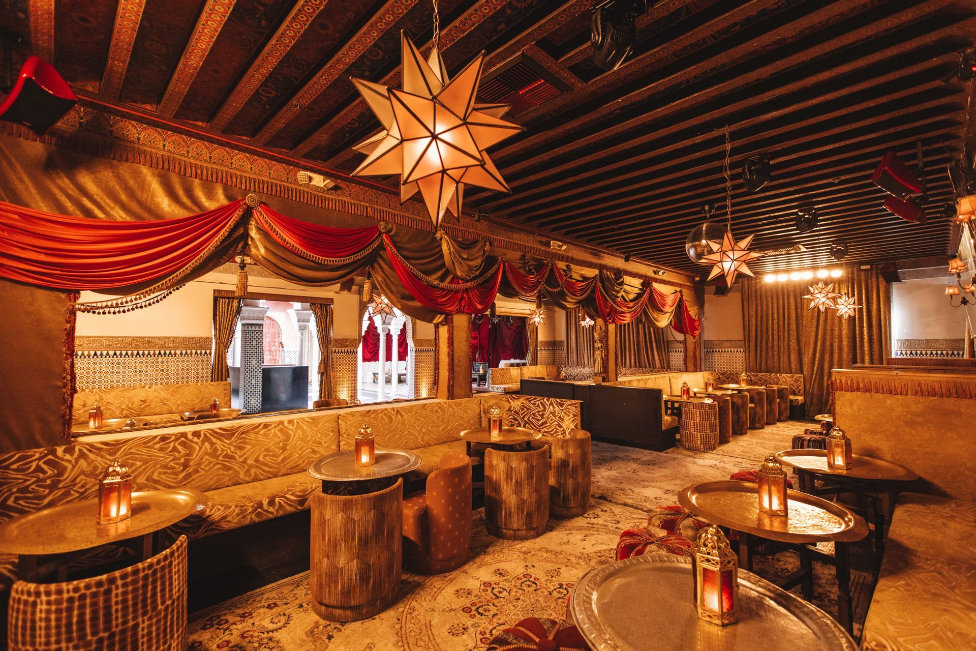 A large room with tables and chairs and a star hanging from the ceiling.