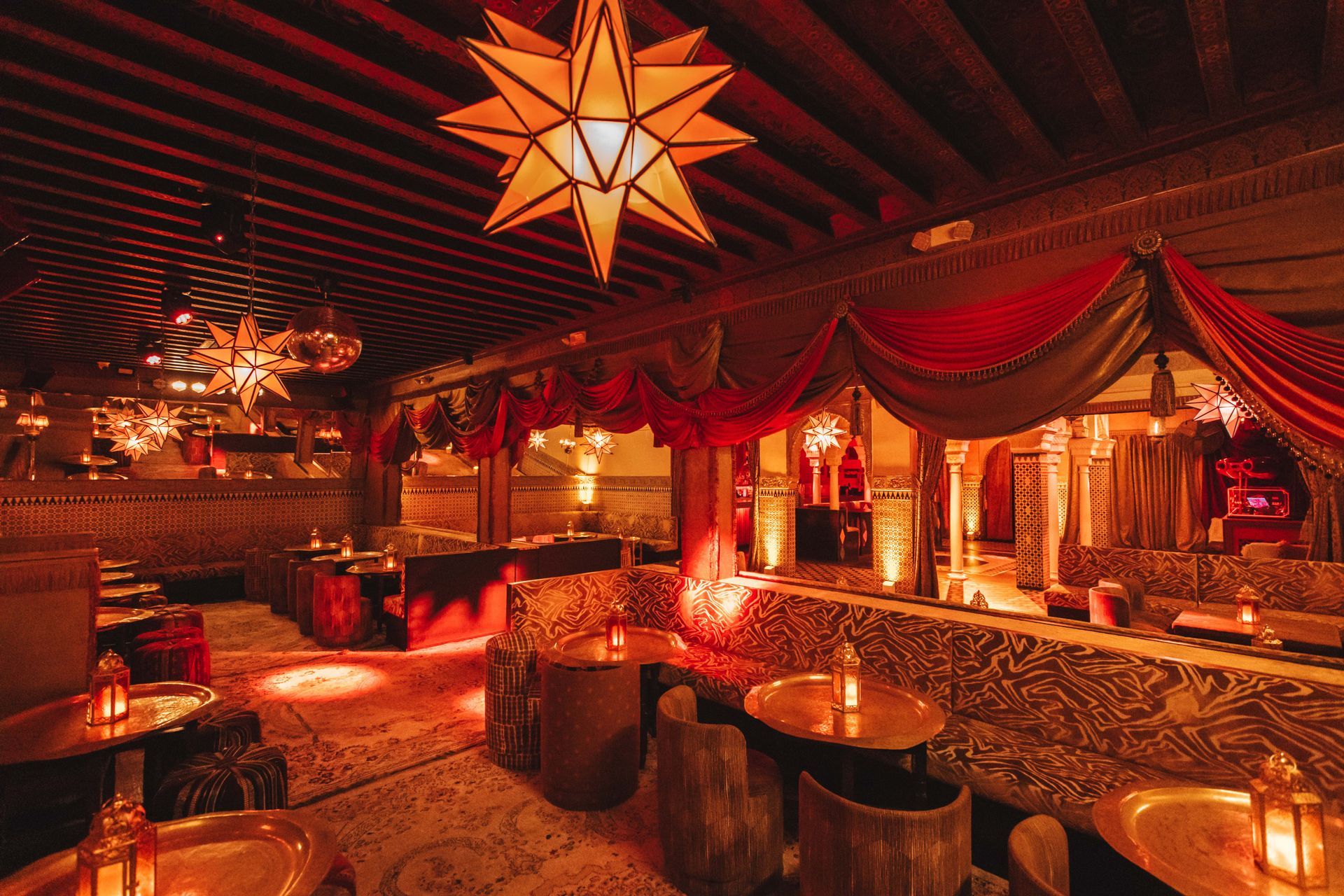A large room with tables and chairs and a star hanging from the ceiling.