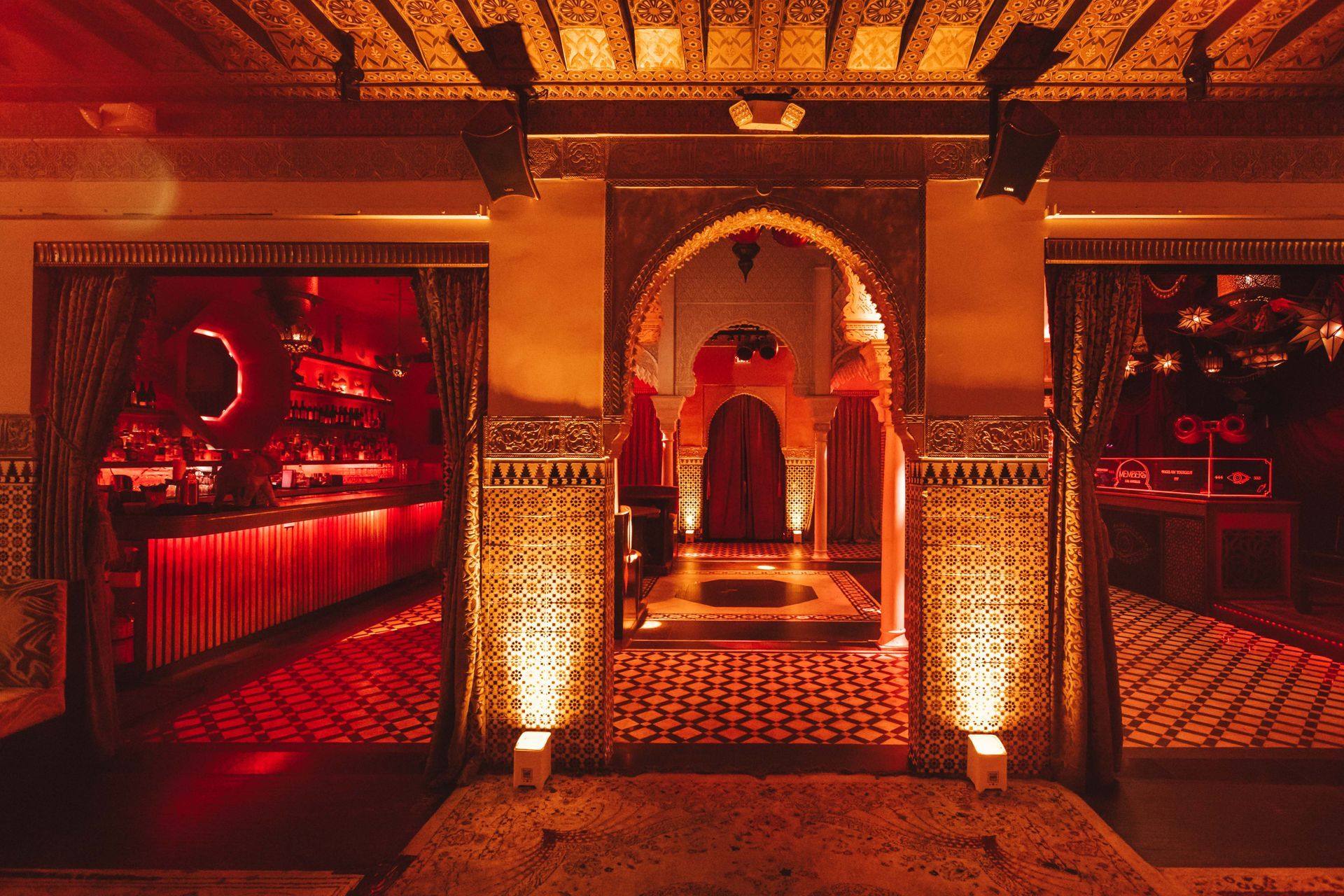 A very ornate room with a red carpet and a very ornate ceiling.