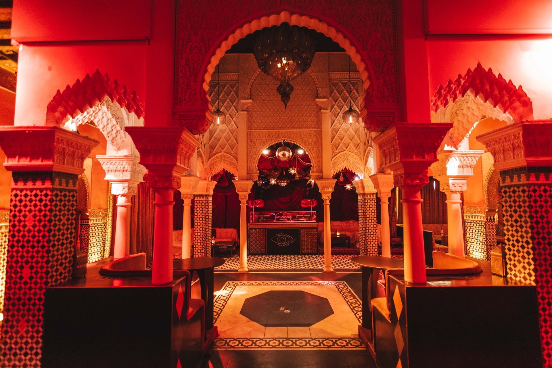A very ornate room with red columns and arches.