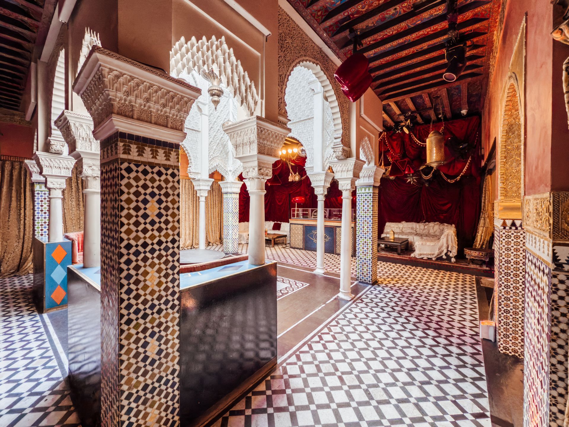 A very ornate room with columns and a checkered floor.