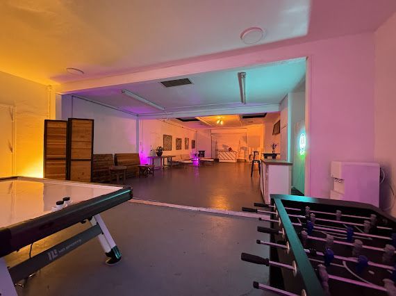 A room with a table and a foosball table in it.