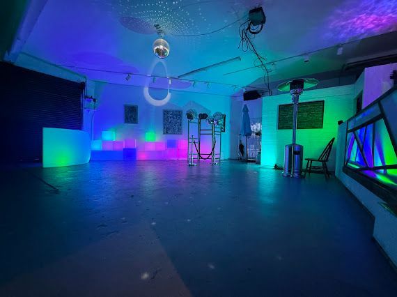 A large empty room with a disco ball hanging from the ceiling.