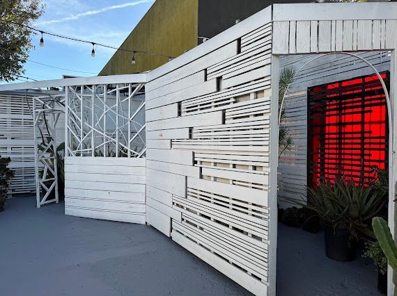 A white fence with a red door in the background.