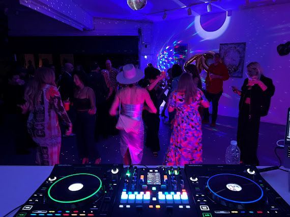 A group of people are dancing at a party in a dark room.