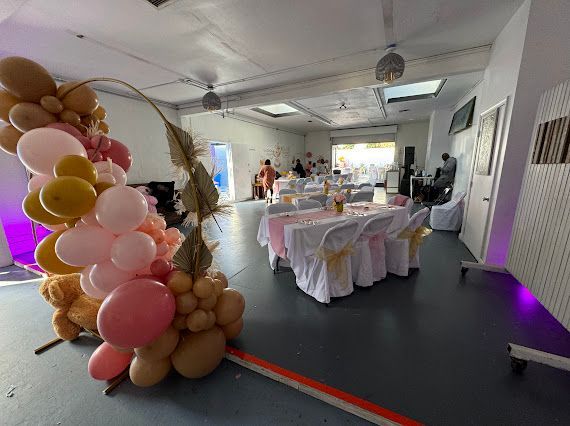A room filled with tables and chairs and balloons.