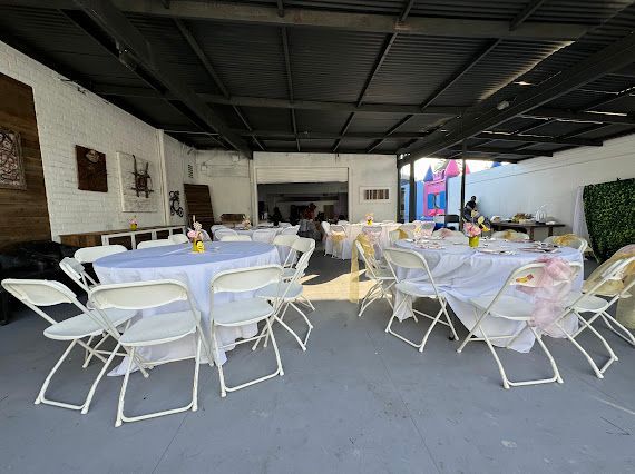 A large room with tables and chairs set up for a party.