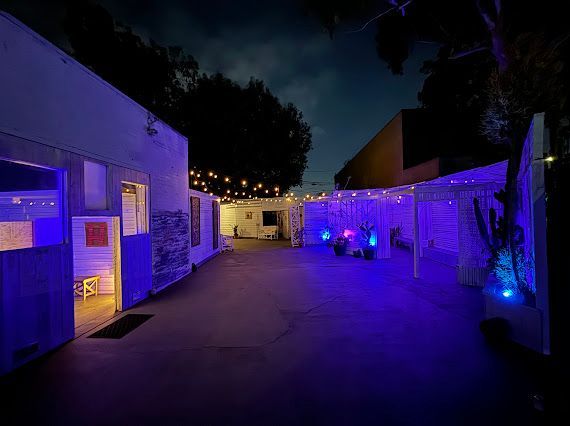 A row of buildings are lit up with purple lights at night.