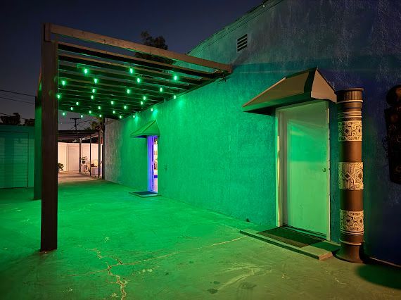 A blue building with green lights on the side of it.