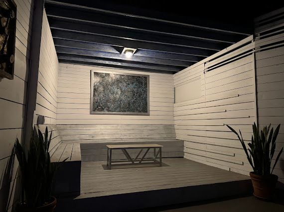 A room with a bench and a picture on the wall