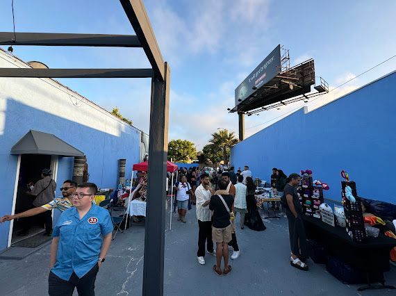 A group of people are standing in front of a blue wall.