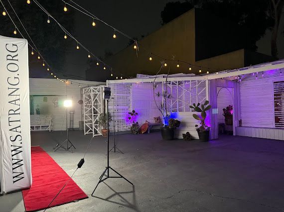 A red carpet is sitting in front of a building with purple lights.