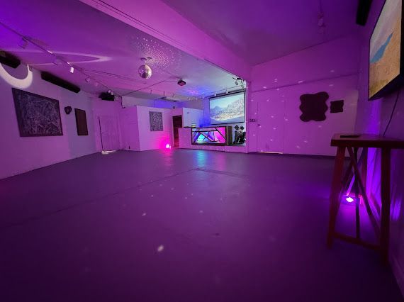 A large empty room with purple lights on the walls and floor.