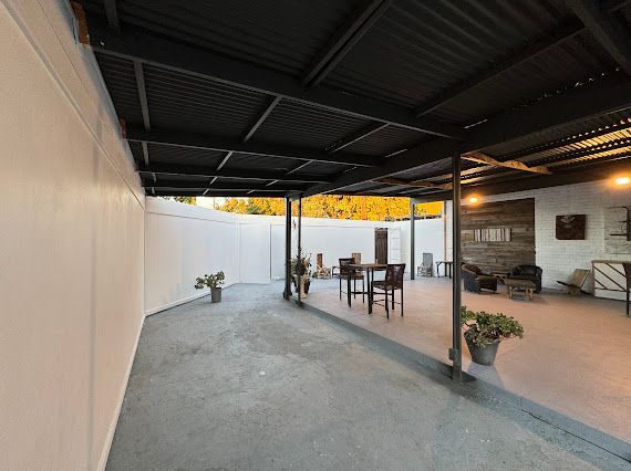 There is a covered patio with a table and chairs underneath it.