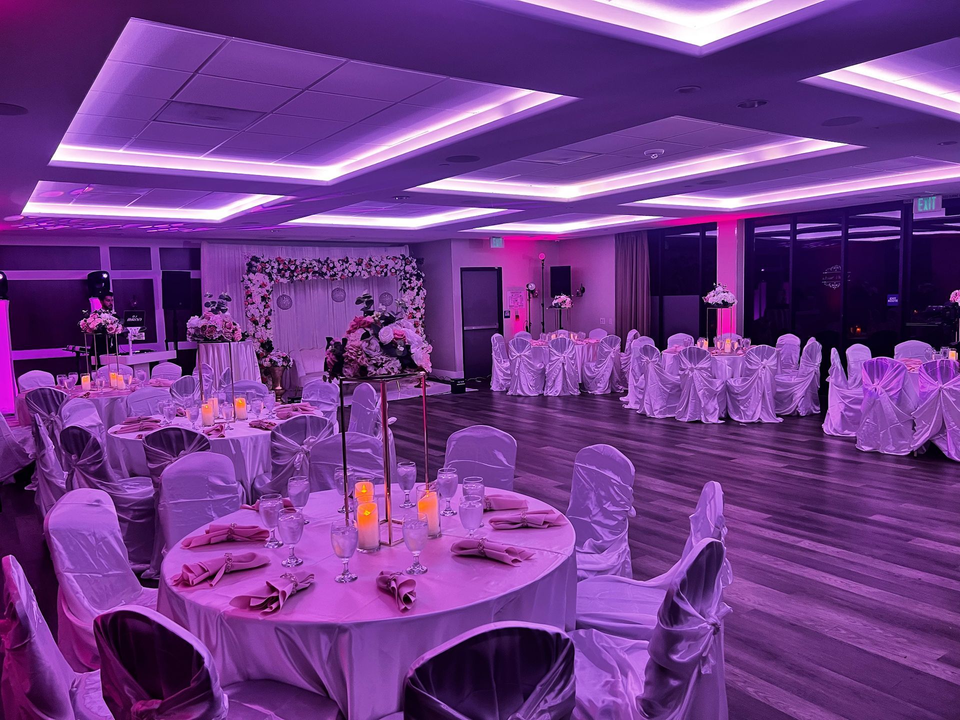A large room with tables and chairs set up for a wedding reception.