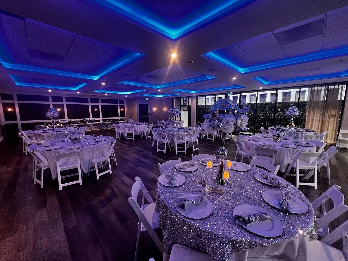 A large room with tables and chairs set up for a wedding reception.