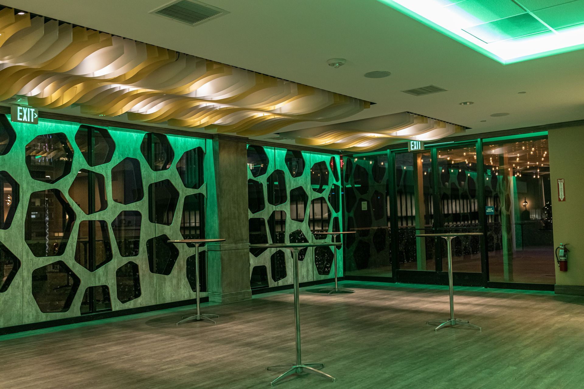 A large room with tables and a green light on the ceiling.