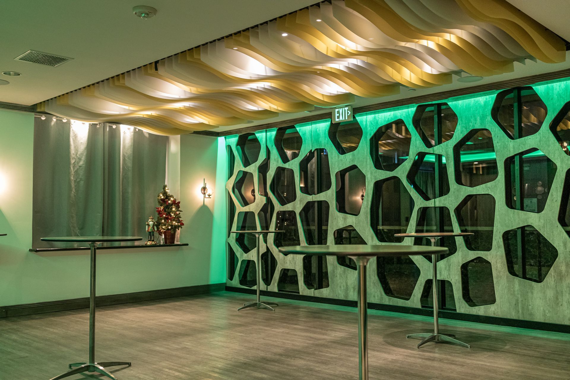 A room with tables and a green wall.
