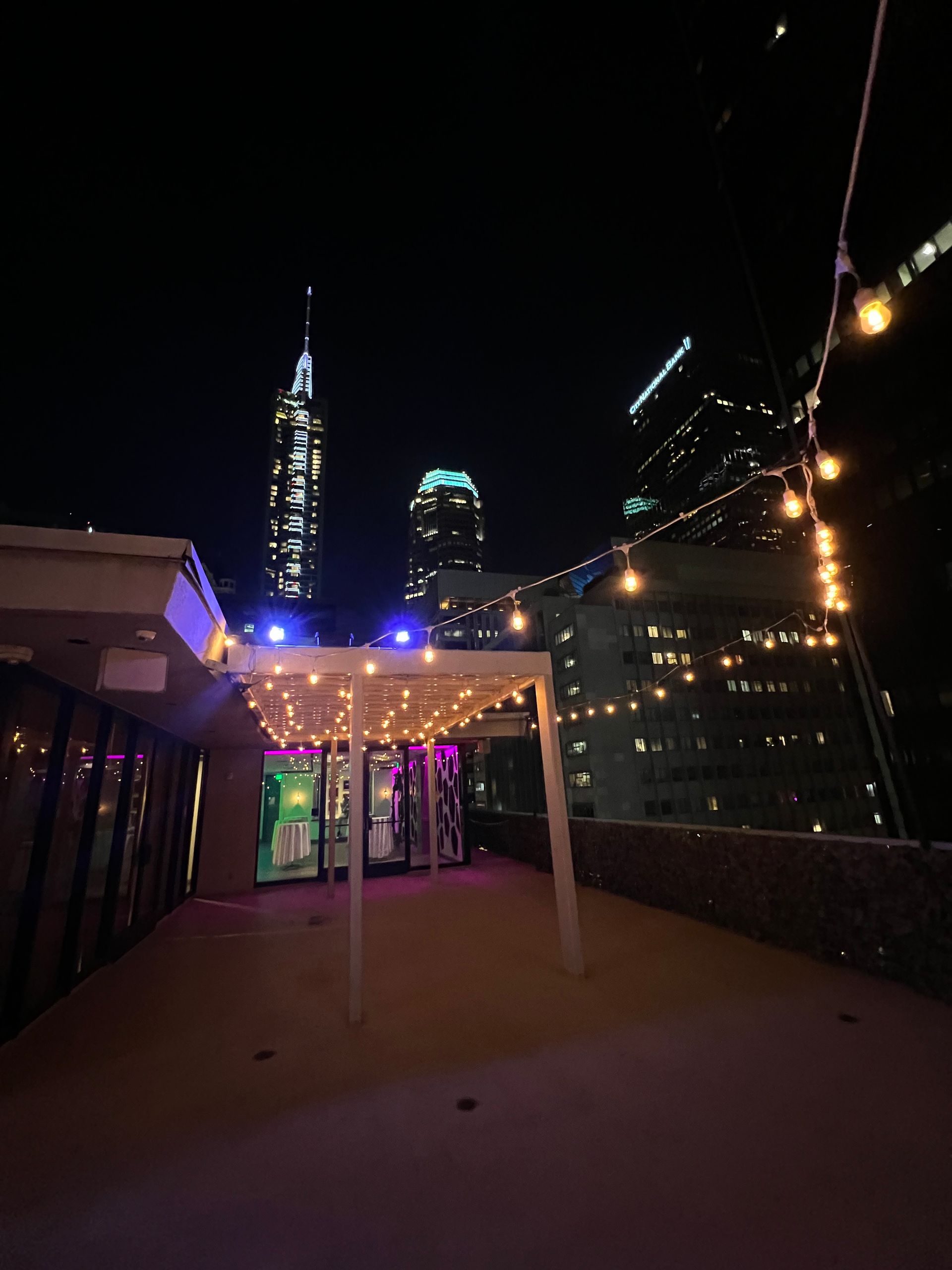 A rooftop at night with a city skyline in the background