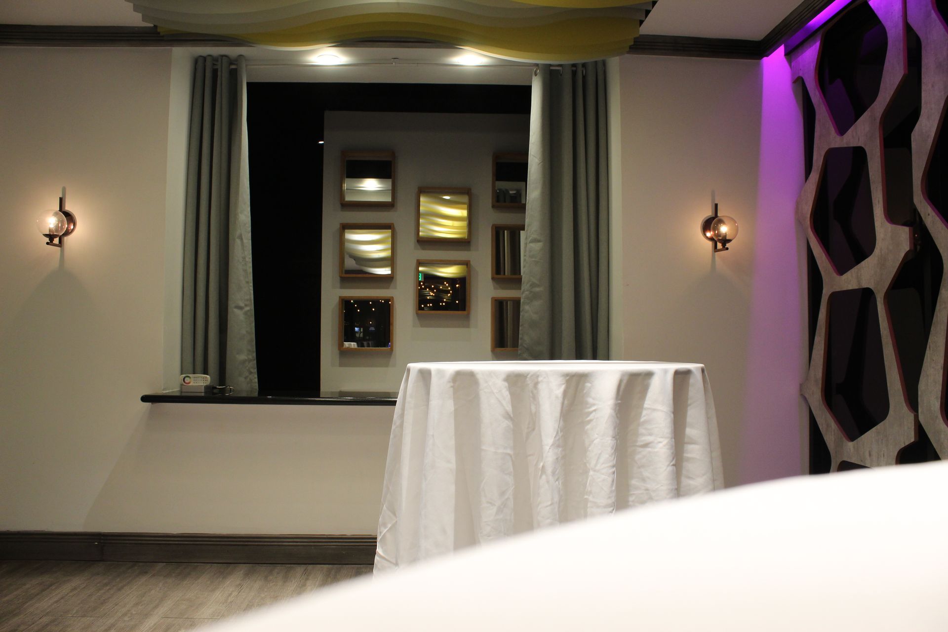 There is a table with a white tablecloth in the middle of the room.