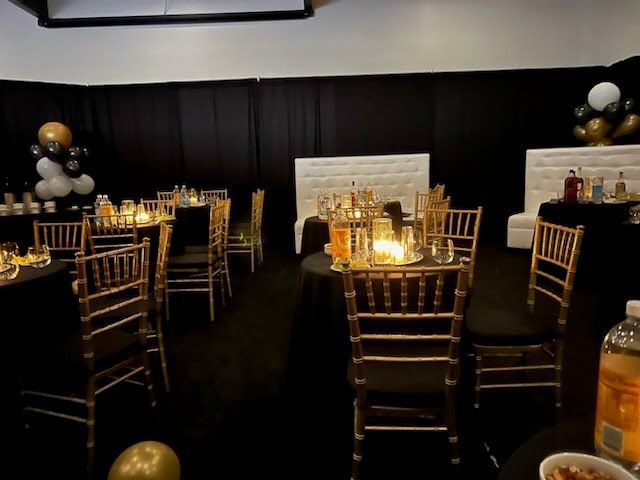 A room with tables and chairs set up for a party.