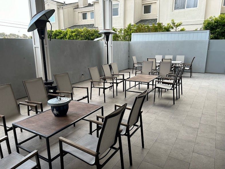 A patio with tables and chairs and a fire pit