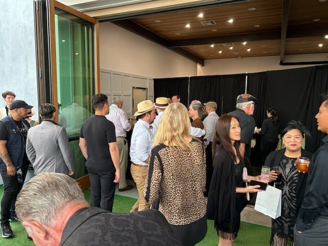 A group of people are standing in a room talking to each other.