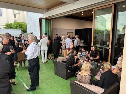 A group of people are standing and sitting on a patio.