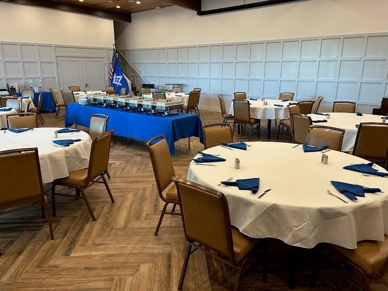 A large room with tables and chairs set up for a banquet.