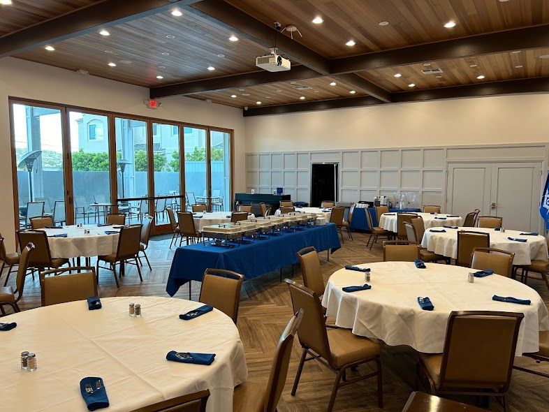 A large room with tables and chairs set up for a banquet.