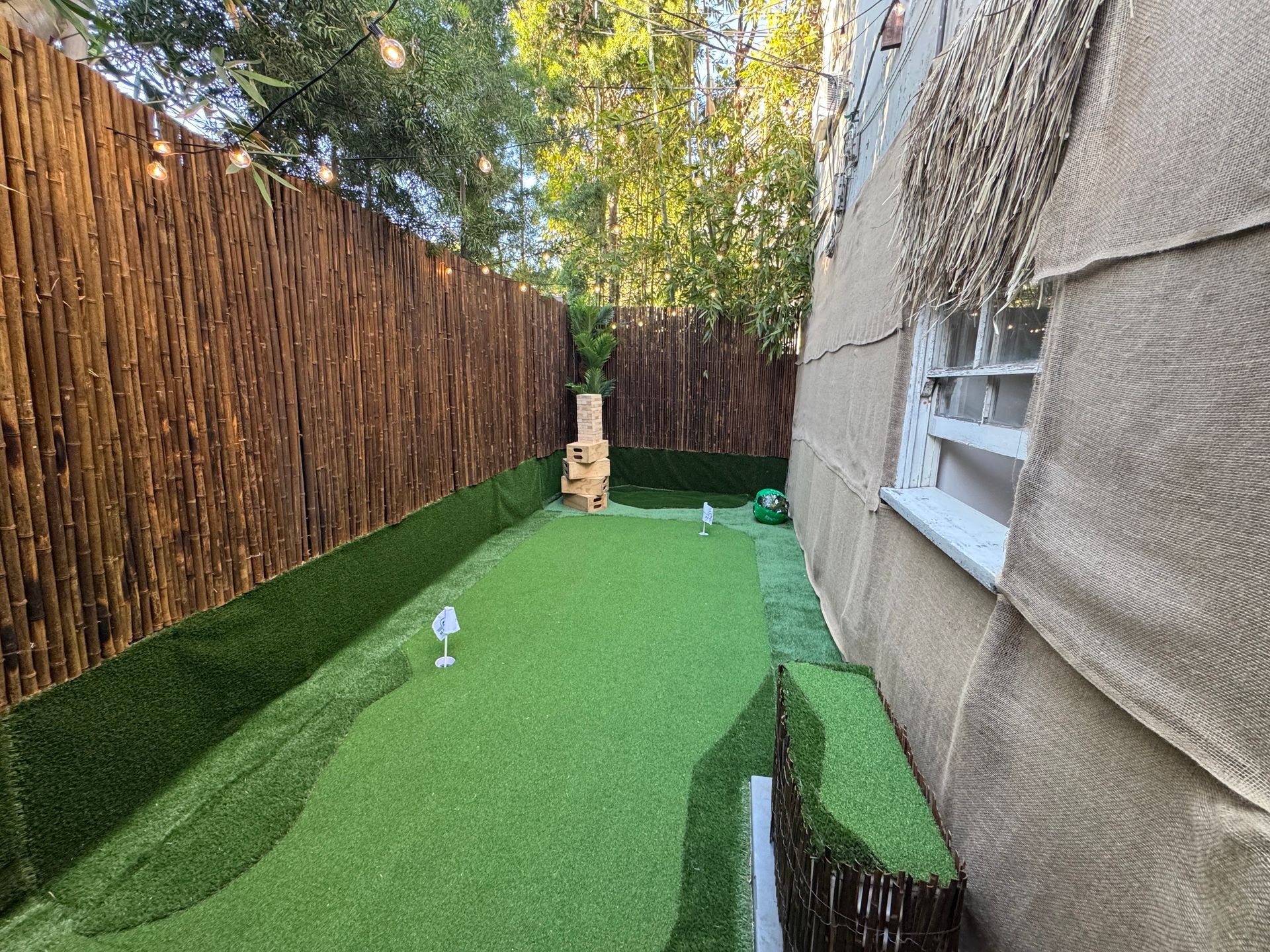 A backyard with a fence and a lush green lawn.