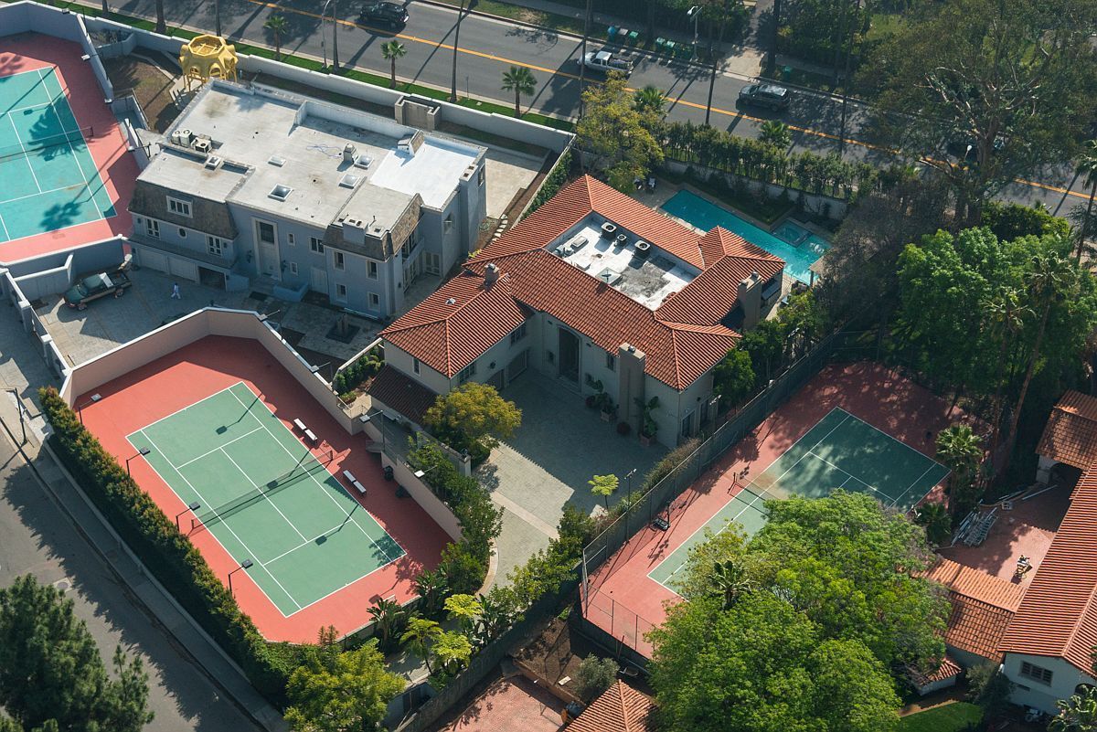An aerial view of a tennis court and swimming pool