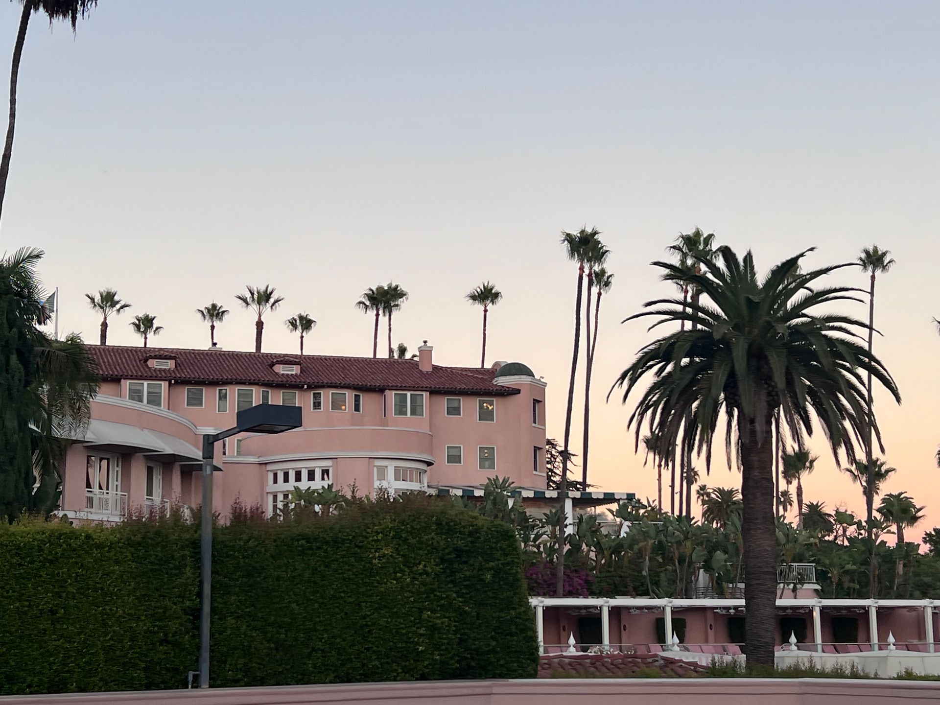 A large pink building with palm trees in front of it