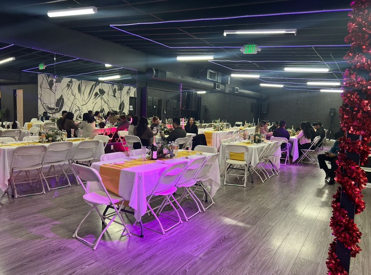 A large room with tables and chairs set up for a party.