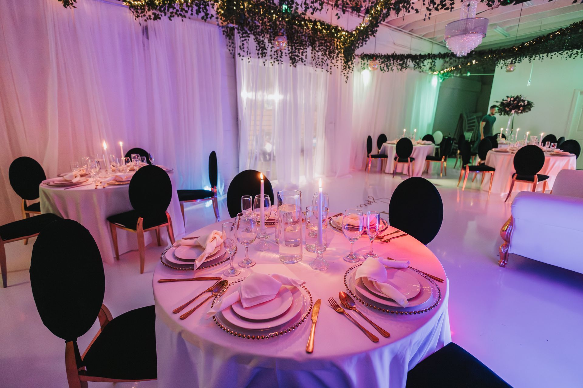 A large room with tables and chairs set up for a wedding reception.
