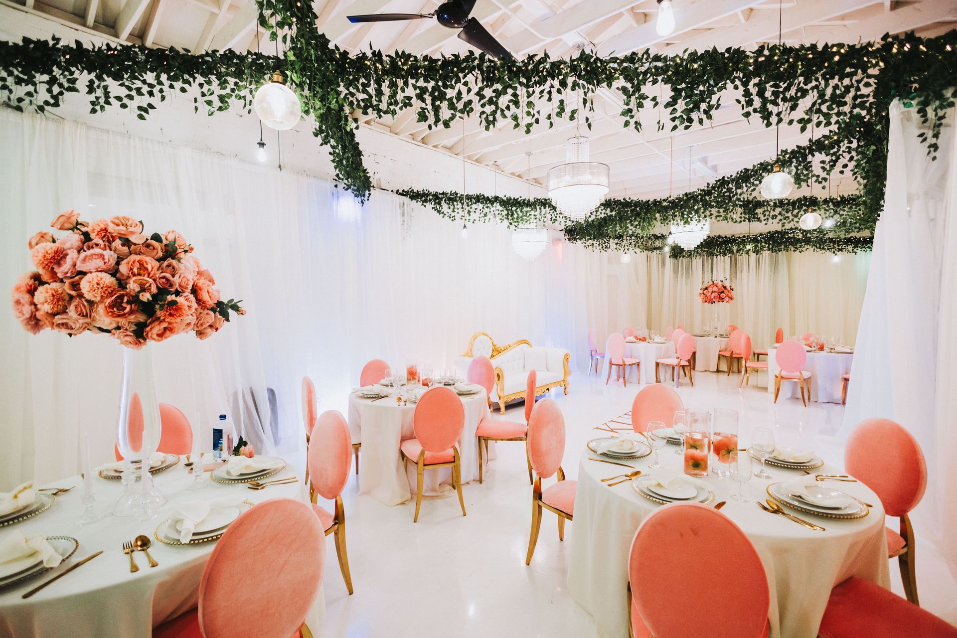A large room with tables and chairs set up for a wedding reception.