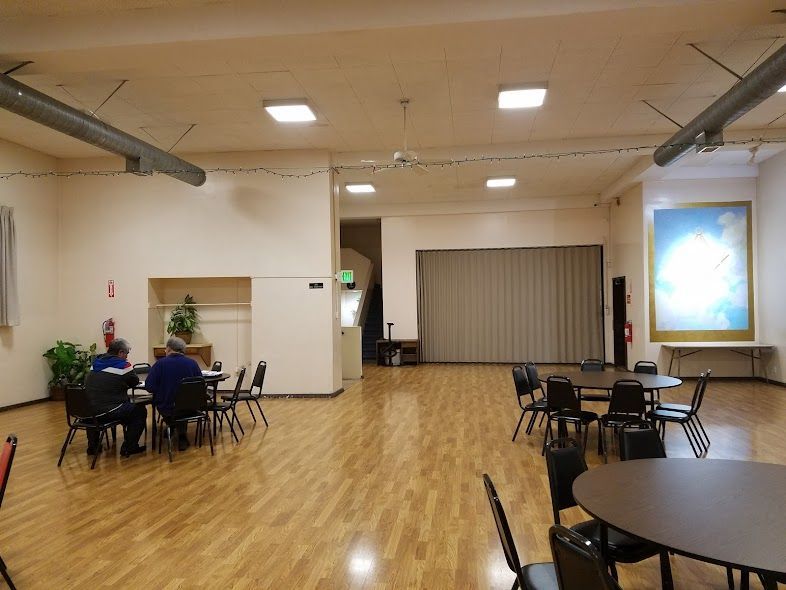 A group of people are sitting at tables in a large room.