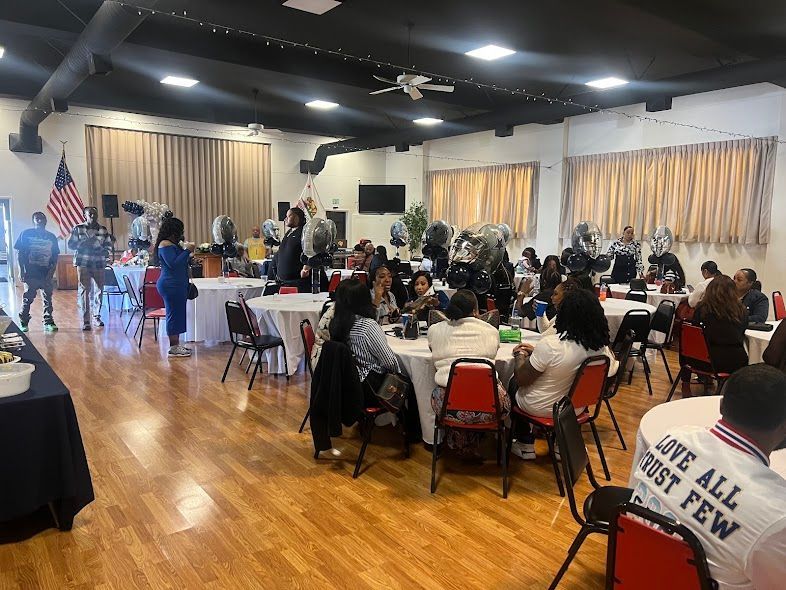 A large room filled with people sitting at tables and chairs.