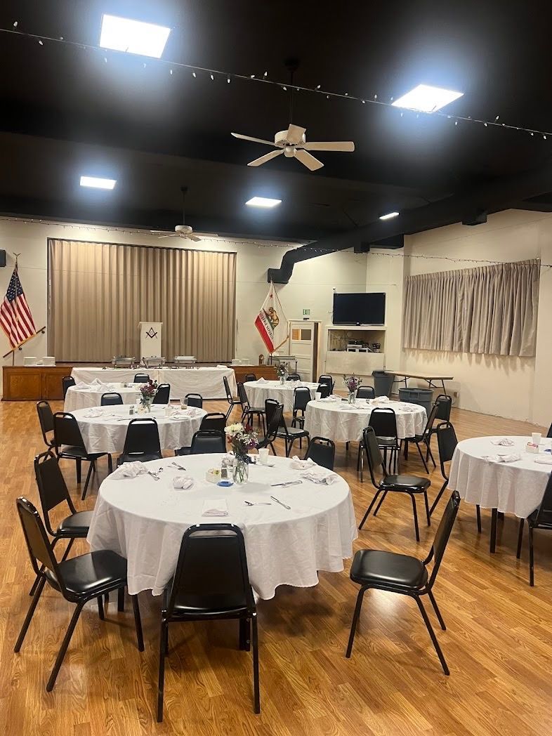 A large room with tables and chairs set up for a party.