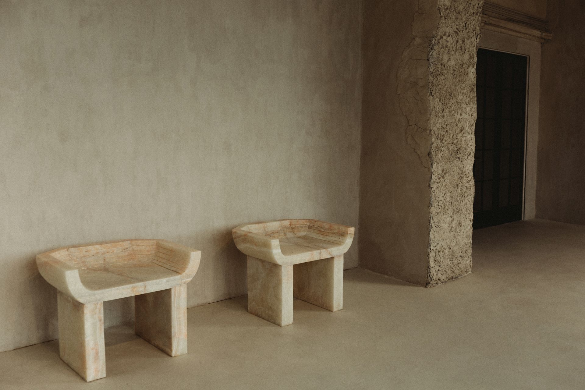 Two stone stools are sitting next to each other in a room.