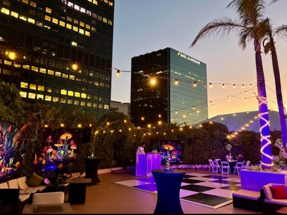 A large building in the background is lit up at night.
