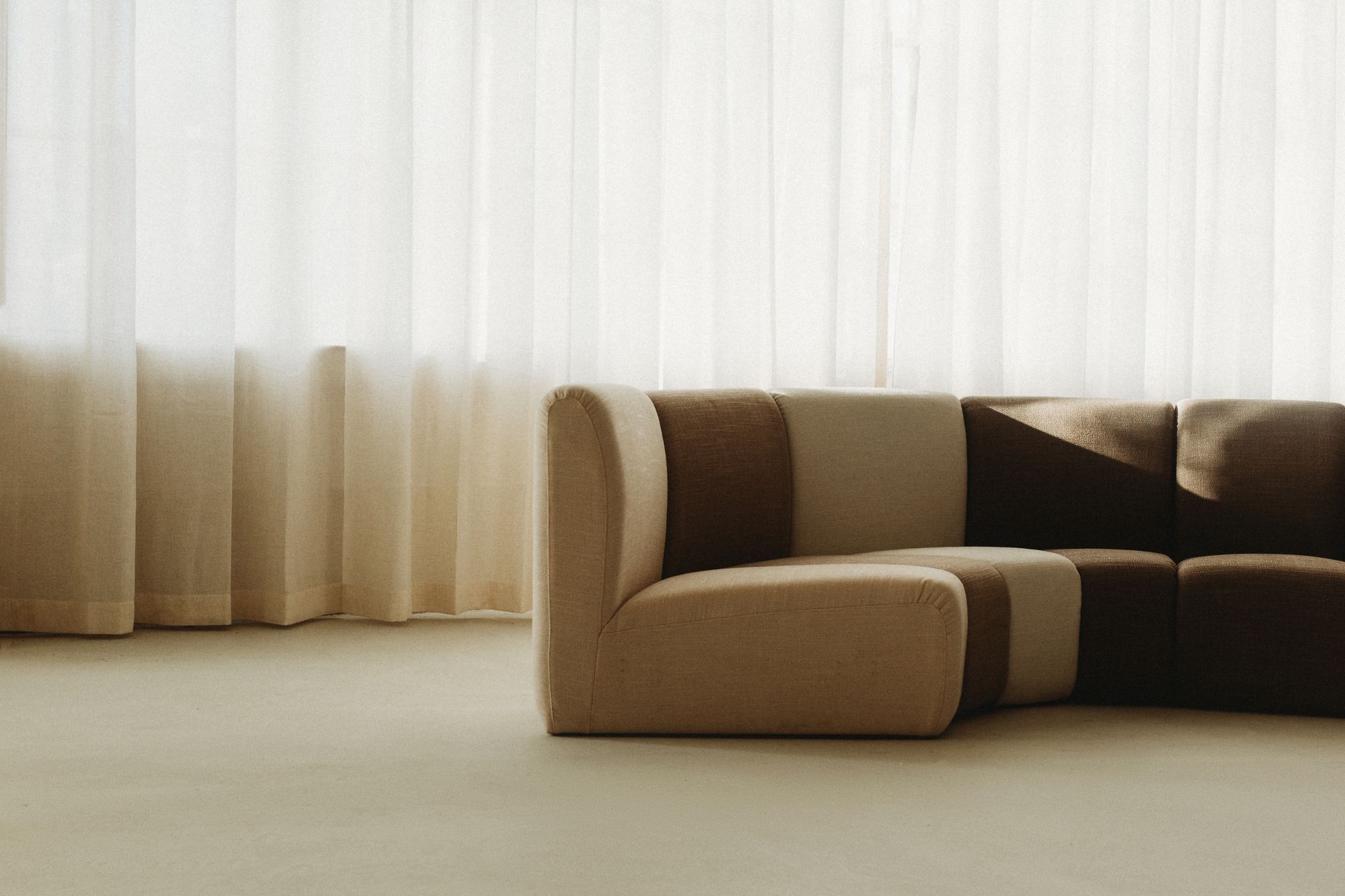 A couch is sitting in front of a window in a living room