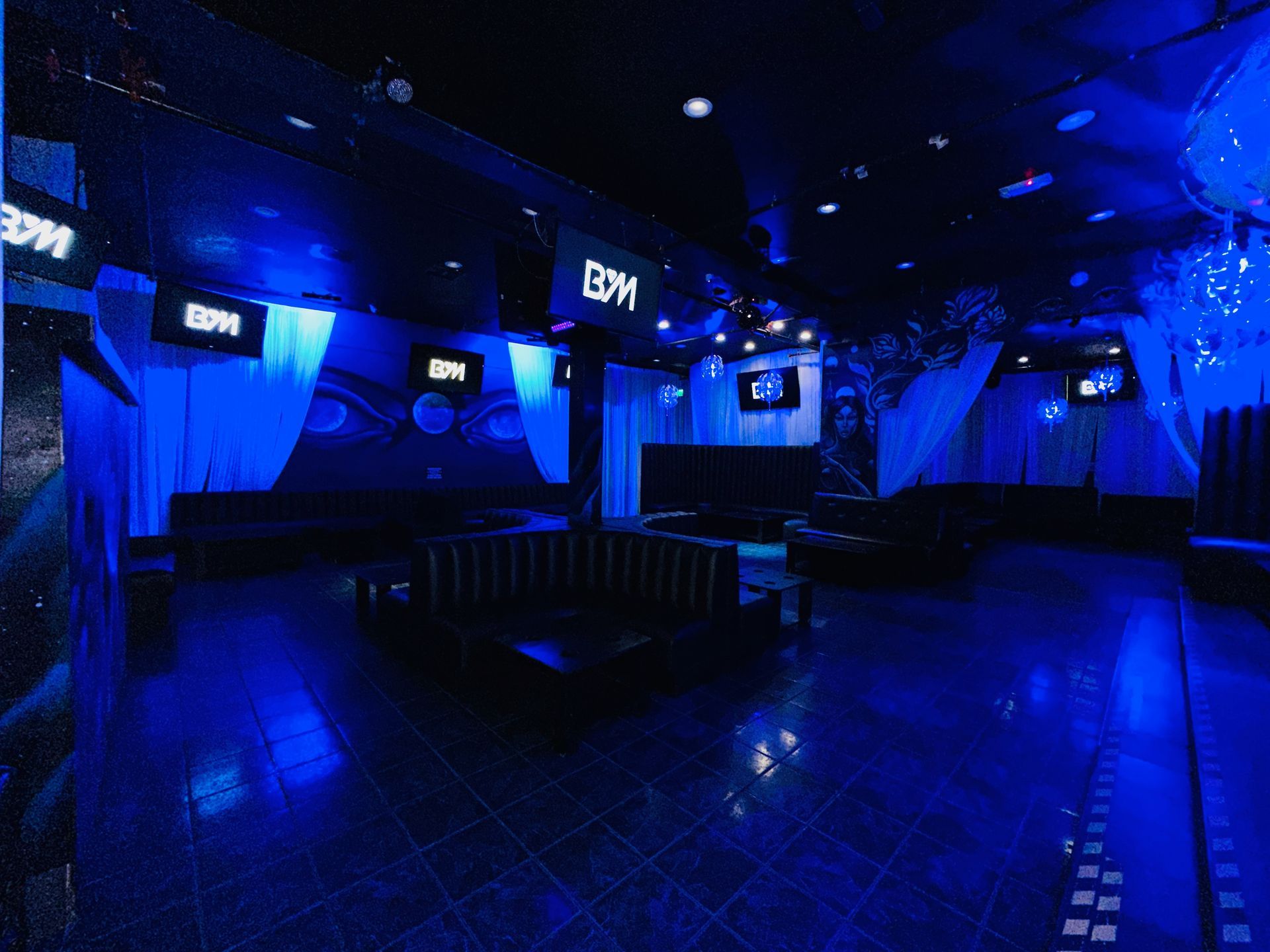 A large empty room with blue lights and a sign that says edm