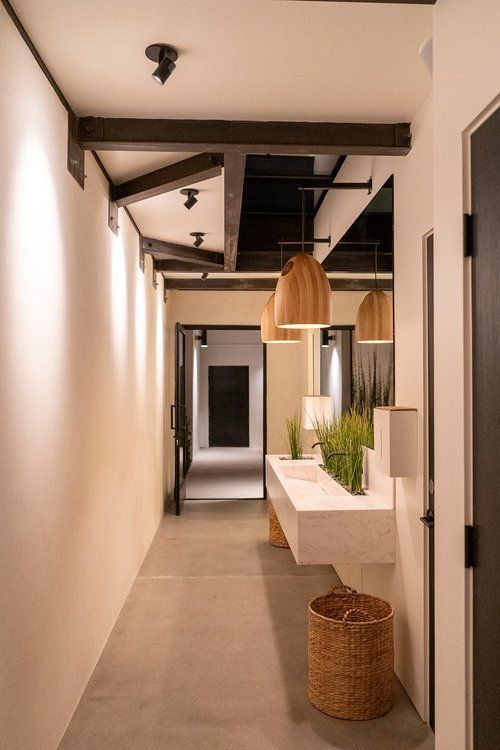 A long hallway with a sink in the middle of it.