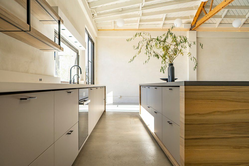 A kitchen with white cabinets and a wooden counter top.