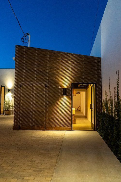 A building with a brick walkway leading to it is lit up at night.