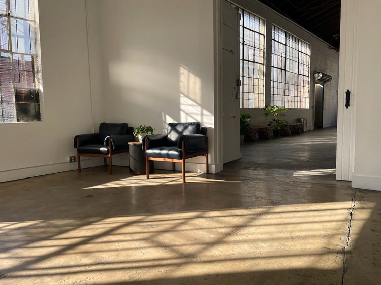 Two chairs are sitting in a room with a lot of windows.