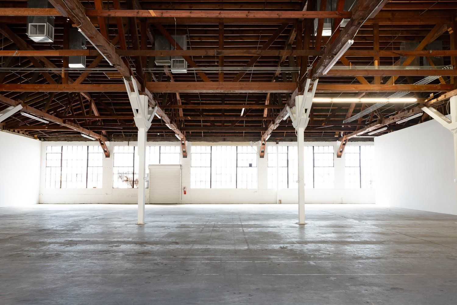 An empty building with a lot of windows and wooden beams